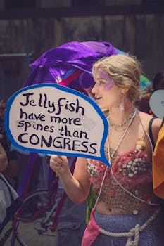 Person in a creative costume holding a sign with political message at outdoor festival.