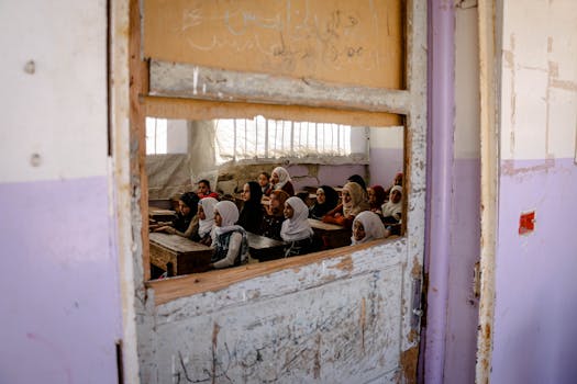 A group of girls attending class in a rundown school in Idlib, Syria, showcasing resilience amid challenging conditions.