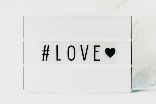 Contemporary minimalist sign displaying '#LOVE' in text with a black heart on a white background.